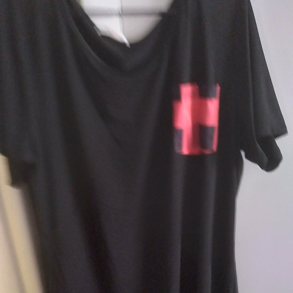 Black short sleeve top with red pocket detail.